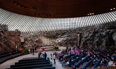 Helsinki, Finlandiya, 19 Temmuz 2024: Finlandiya 'nın başkenti Helsinki' de doğrudan kayaya oyulmuş temppeliaukio kilisesinin içindeki insanlar