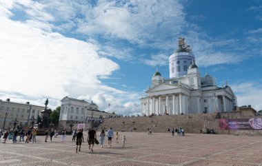 Helsinki Finlandiya, 18 Temmuz 2024: Güneşli bir yaz gününde Helsinki Katedrali ile birlikte Helsinki 'nin ünlü simgesi olan senato meydanında yürüyen turistler