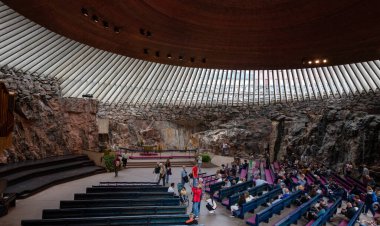 Helsinki, Finlandiya, 19 Temmuz 2024: Finlandiya 'nın başkenti Helsinki' de doğrudan kayaya oyulmuş temppeliaukio kilisesinin içindeki insanlar