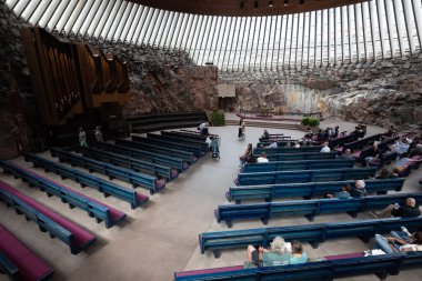 Helsinki, Finlandiya, 19 Temmuz 2024: Finlandiya 'nın başkenti Helsinki' de doğrudan kayaya oyulmuş temppeliaukio kilisesinin içindeki insanlar