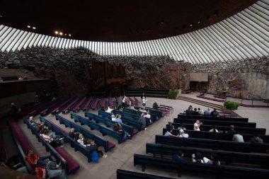 Helsinki, Finland, July 19 2024: People inside temppeliaukio church rock church, carved directly into solid rock, in helsinki, finland clipart