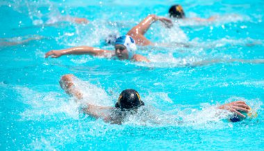 Yüzme havuzunda su topu oynayan sporcular. Sucul sporu. Şampiyonluk yarışması.
