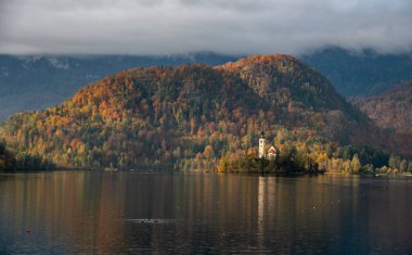 Mary Hac Kilisesi 'nin sakin gölü yansıttığı varsayımı kanıyordu. Dağlar ve renkli sonbahar yapraklarıyla çevrelenmişti.