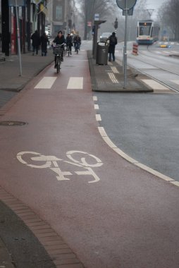 Bisikletçi, sürdürülebilir ulaşımı teşvik etmek için şehir ortamında kendini adamış bir bisiklet yolu kullanıyor. Bisiklet yolu. Amsterdam