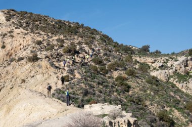Bir grup insan yürüyüş parkurunda doğa yürüyüşü yapıyor. Sağlıklı bir yaşam tarzı. Açık havada egzersiz yapıyorum. Cape Aspro, Kıbrıs Rum Kesimi