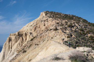 Group of people trekking in nature on a hiking trail. Healthy lifestyle. Exercising outdoor. Cape Aspro, Pissouri Cyprus clipart