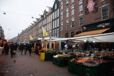 Amsterdam, Hollanda, 12 Şubat 2025: Müşteriler Hollanda, Amsterdam 'da popüler bir sokak pazarı olan Albert Cuypmarkt' ta taze meyve ve sebzelere göz atıyorlar