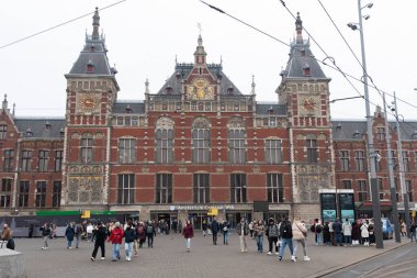 Amsterdam, Hollanda, 9 Şubat 2025: Hollanda 'nın kuzeyindeki Amsterdam Centraal İstasyonu önünde turistler ve yerliler yürüyor ve gidip geliyorlar