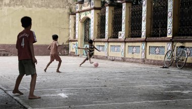 Hanoi, Vietman, 7 Ağustos 2010: Vietnam 'daki eski binanın avlusunda futbol oynayan çocuklar