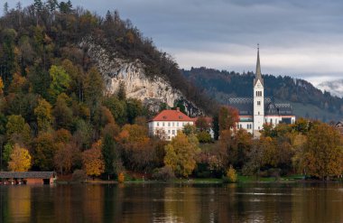 Göl manzarası St. Martins kilisesi ve kan içinde, Slovakya 'da renkli sonbahar yapraklarıyla doldu.