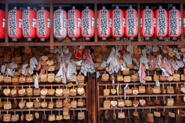 Kyoto, Japonya, 21 Nisan 2025: Tahta film ve Japon tapınağında asılı kırmızı çene, dualar, dilekler ve geleneksel Japon kültürü sergilenmektedir.