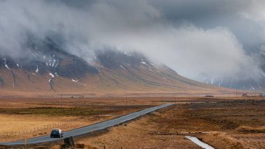 İzlanda 'daki Snaefellsnes yarımadasındaki karlı dağlara giden düz bir yol. İzlanda manzarası