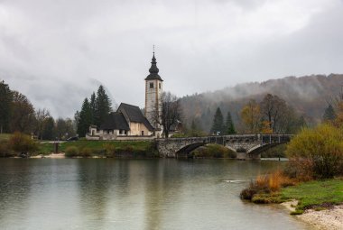 Sisli bir sonbahar gününde Bohinj Gölü kıyısındaki Vaftizci Yahya 'nın Kilisesi' nin sakin manzarası.