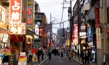 Yokohama, Japonya, 26 Nisan 2025. Çin şehrinin gece manzarası, reklam panoları, market tezgahları ve Yokohama, Japonya sokaklarında yürüyen insanlar..