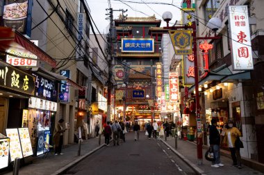 Yokohama, Japonya, 26 Nisan 2025. Çin şehrinin gece manzarası, reklam panoları, market tezgahları ve Yokohama, Japonya sokaklarında yürüyen insanlar..