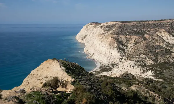 Bir grup insan yürüyüş parkurunda bir uçurumun kenarında yürüyüş yapıyor. Sağlıklı bir yaşam tarzı. Açık havada egzersiz yapıyorum. Cape Aspro, Kıbrıs Rum Kesimi