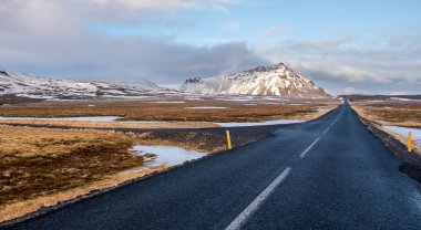 Tipik İzlanda karlı dağ manzarası ve İzlanda 'nın Snaefellsnes yarımadasındaki Arnarstapi bölgesi yakınlarındaki boş yol.