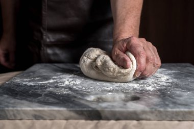 Pizza hazırlayan adam, mermer masada hamur..