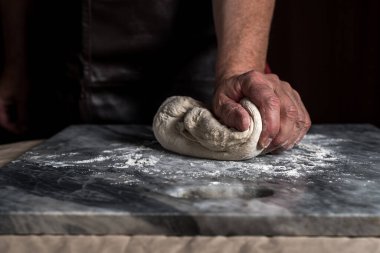 Pizza hazırlayan adam, mermer masada hamur..