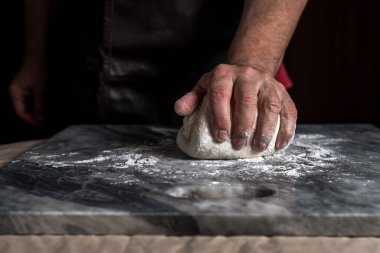 Pizza hazırlayan adam, mermer masada hamur..