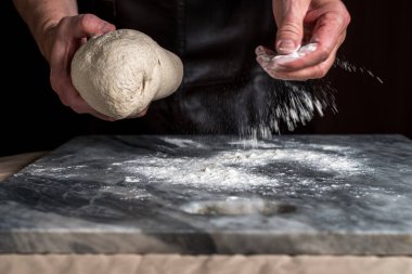 Pizza hazırlayan adam, mermer masada hamur..