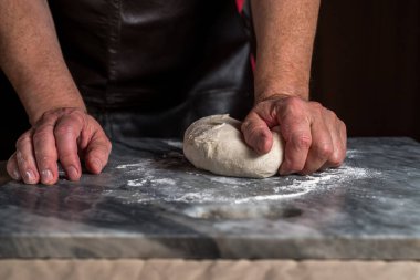 Pizza hazırlayan adam, mermer masada hamur..