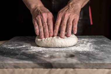 Pizza hazırlayan adam, mermer masada hamur..