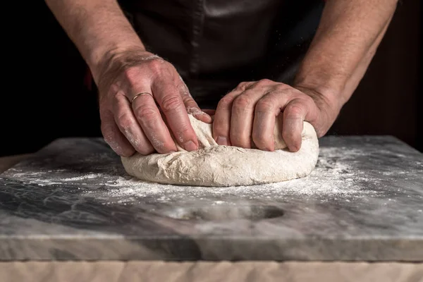 Pizza hazırlayan adam, mermer masada hamur..