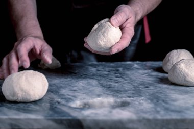 Pizza hazırlayan adam, mermer masada hamur..