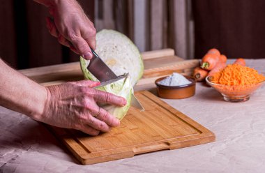 Kesme tahtasında lahana, yanında bıçak ve havuç..