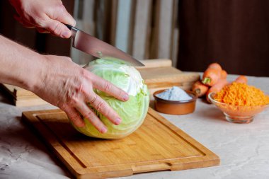 Kesme tahtasında lahana, yanında bıçak ve havuç..