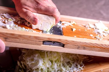 Mayalanma için lahana hazırlayın. Kesiciyle lahana doğrama. Ev yapımı lahana turşusu..