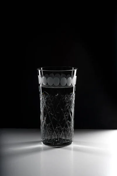 Glass of drink water with gas on black background.