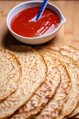 Sıcak, taze pişmiş reçelli krep. Beyaz seramik kasede ev yapımı gül suyu (rosa canina) marmeladı. Gözlemelerin makro fotoğrafçılığı, kreplerin yakın çekimi. Bir yığın gözlemeden kahvaltı, yakın plan. Makro yemek fotoğrafı. Güzel yemek örtüsü..