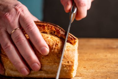 man cutting homemade bread. Home baked sourdough breads. Fresh, homemade sourdough breads.