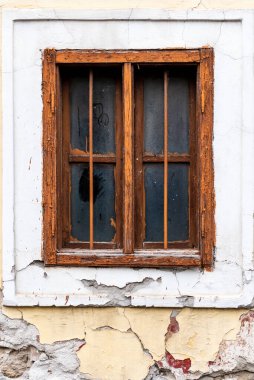 Penceresi olan eski çatlak bir duvar. Eski evin penceresi. Kahverengi çerçeveli eski pencere.