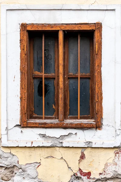 Stock image Old cracked wall with a window. window of old house. Old window with brown frame.