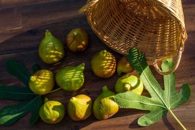 Kahverengi ahşap arka planda birkaç sarı incir..