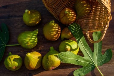 Kahverengi ahşap arka planda birkaç sarı incir..