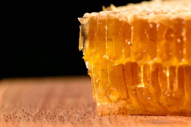 - Tatlım. Doğal bal ve bal peteği. Ahşap kesme tahtasındaki lezzetli organik bal peteğine yaklaş..