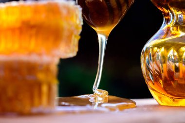 - Tatlım. Doğal bal ve bal peteği. Tatlı bal dökülüyor. Ahşap kesme tahtasındaki lezzetli organik bal peteğine yaklaş..