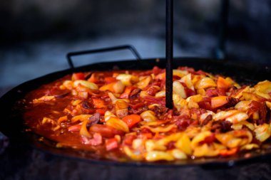Letcho, kabaklı yahni ve sosis. Kazanda açık havada yemek pişirmek. Pişirilen yemek 