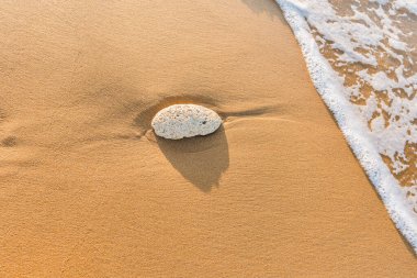 Sahildeki taşların yüksek açılı görüntüsü. Kumsalda köpük.