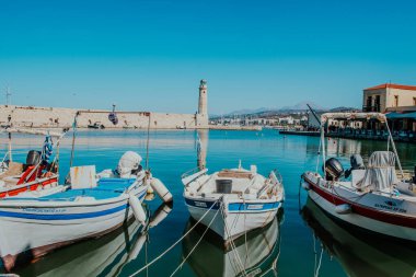 Venedik limanındaki eski deniz feneri. Eski Rethymno kasabasının körfezinde tekneler, yatlar ve küçük tekneler.