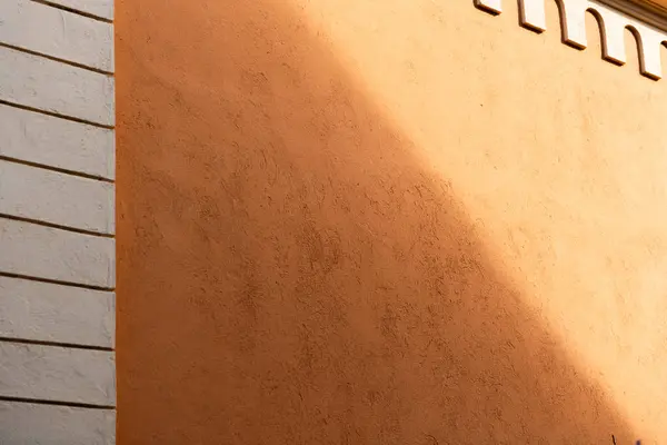 Background. Orange painted building wall with shadows