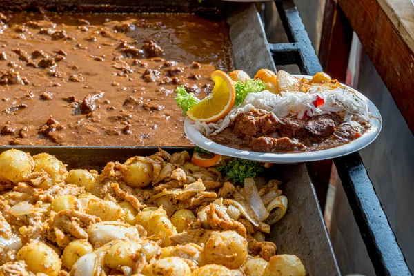 Sokak yemekleri festivali. Paslanmaz çelik tepsilerde servis edilen çeşitli yiyecekler. Sıradan insanlar için yemek yenecek bir yer. Halk yemekleri..