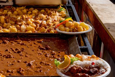 Sokak yemekleri festivali. Paslanmaz çelik tepsilerde servis edilen çeşitli yiyecekler. Sıradan insanlar için yemek yenecek bir yer. Halk yemekleri..