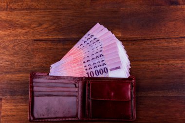 Macar HUF 10,000 banknot cüzdan, kahverengi bir masaya yayılmış ve sıralanmış.