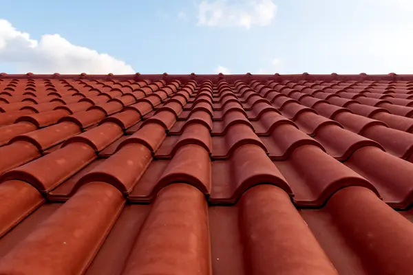 stock image Red tile roof under blue sky. One part is a roof and the other is a pure blue sky.