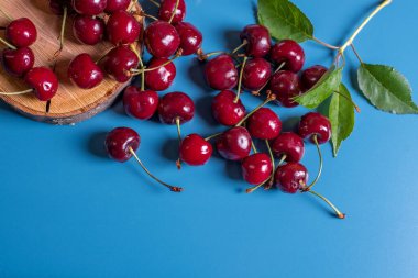 Kirazlı düz yatak. Mavi arka planda taze kirazlar